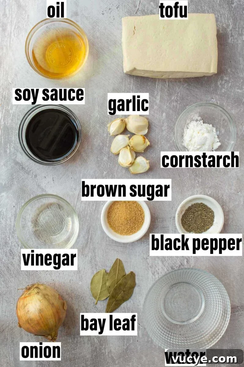 Vegan Tofu Adobo Recipe: Tangy Filipino-Style Comfort Food 3 Labeled ingredients including oil, tofu, soy sauce, garlic, cornstarch, and bay leaves.