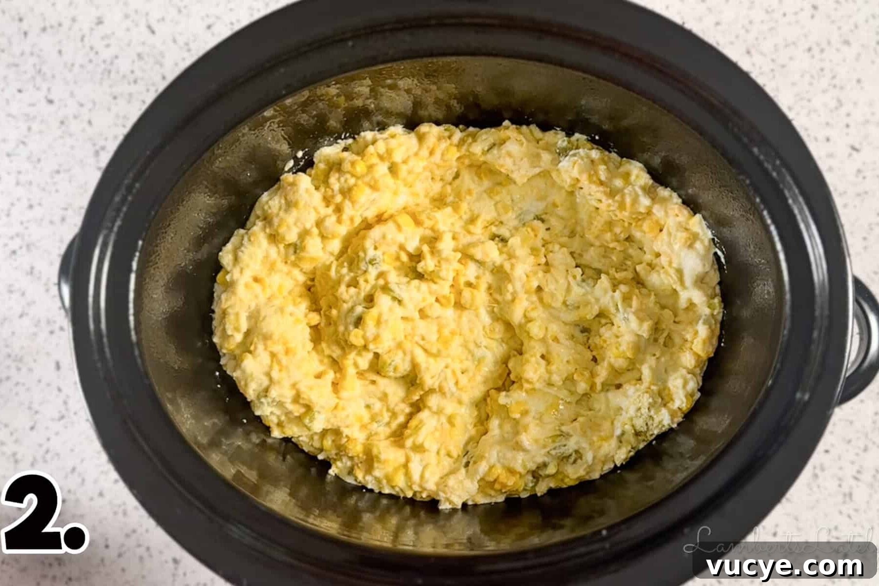 corn casserole mixture in a crock pot before cooking.