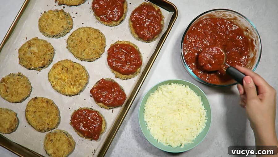 Crispy Baked Eggplant Parmesan (No-Fry, Simple Recipe) 13 crispy eggplant parmesan being topped with homemade marinara sauce