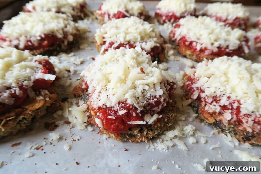 Crispy Baked Eggplant Parmesan (No-Fry, Simple Recipe) 14 crispy eggplant parmesan being topped with cheese