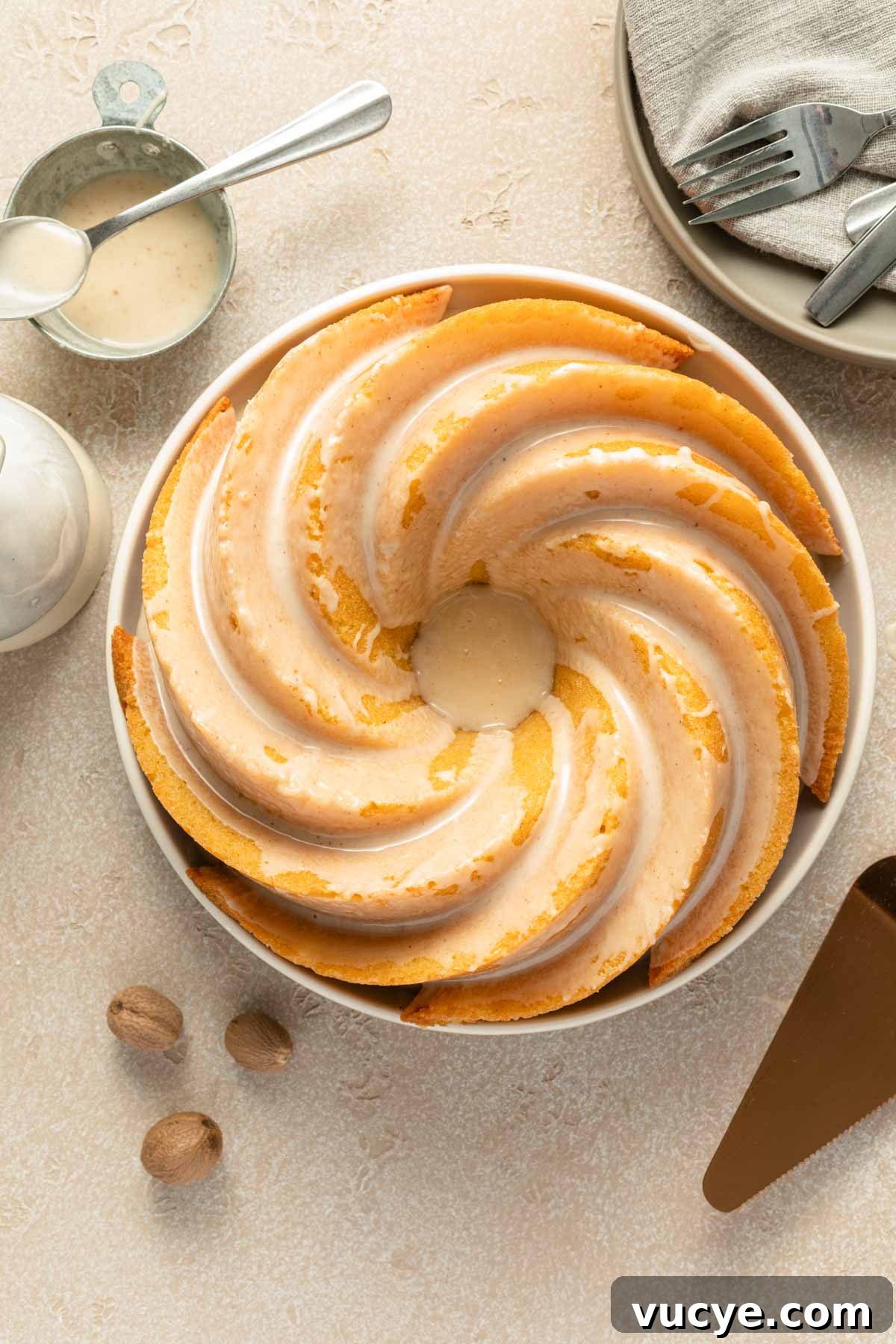Eggnog Bundt Cake Recipe with Spiced Rum Glaze 2 Overhead view of eggnog cake on a plate and topped with eggnog glaze.