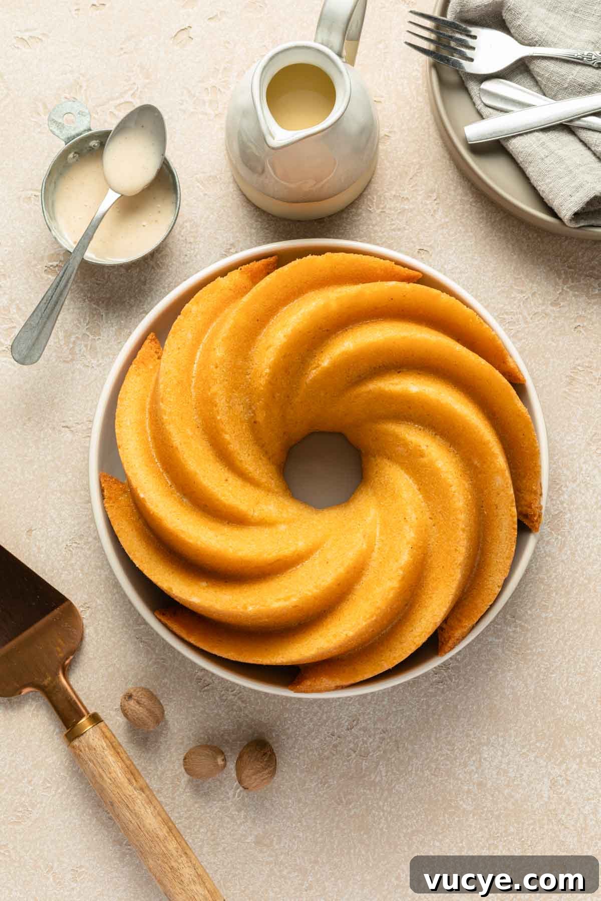Eggnog Bundt Cake Recipe with Spiced Rum Glaze 5 Unglazed bundt cake on a round plate.