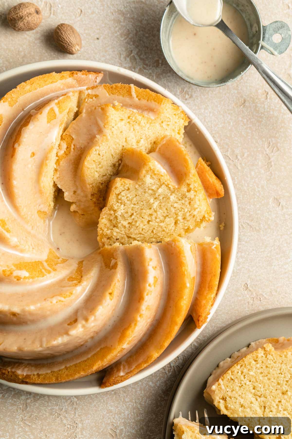 Eggnog Bundt Cake Recipe with Spiced Rum Glaze 7 Overhead view of eggnog cake on a plate and cut into slices.