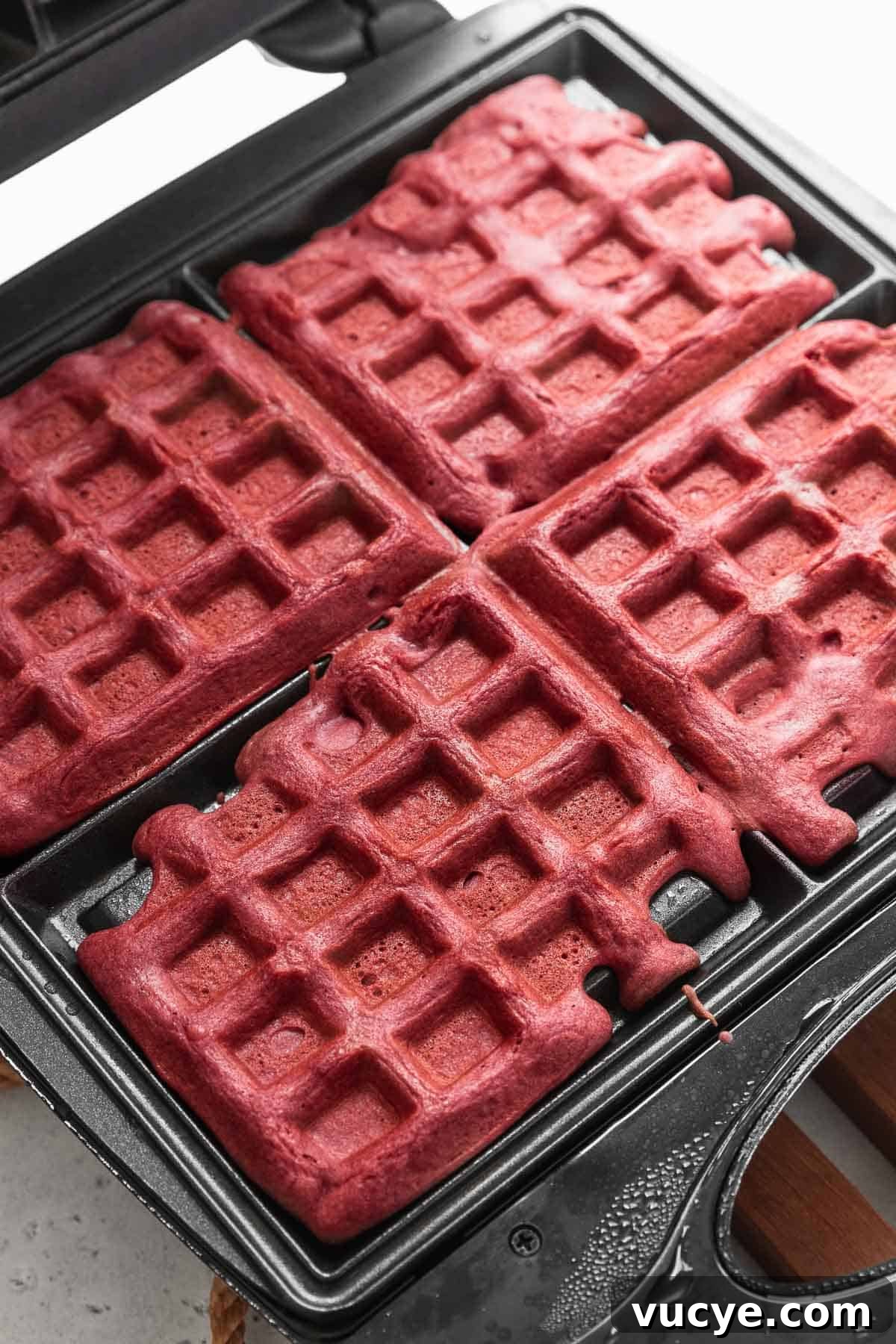Red Velvet Waffles Recipe: fluffy, rich, and irresistible 8 Baked red velvet waffles still in the waffle maker.