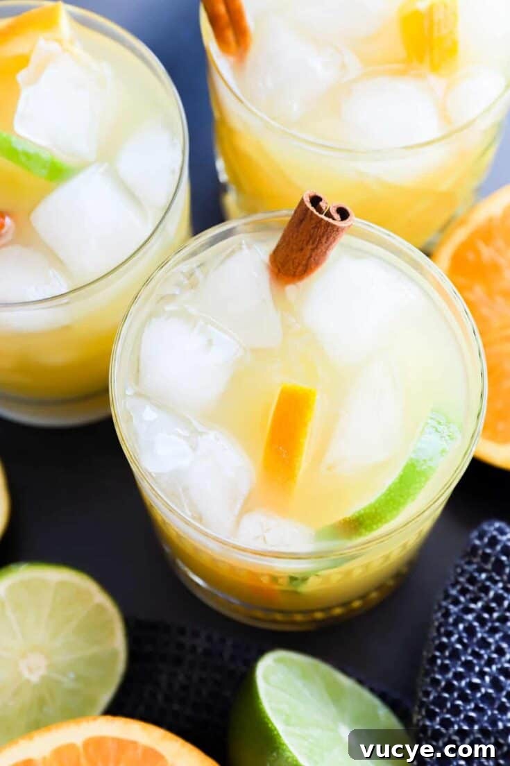 Spiced rum punch cocktails garnished with a cinnamon stick.