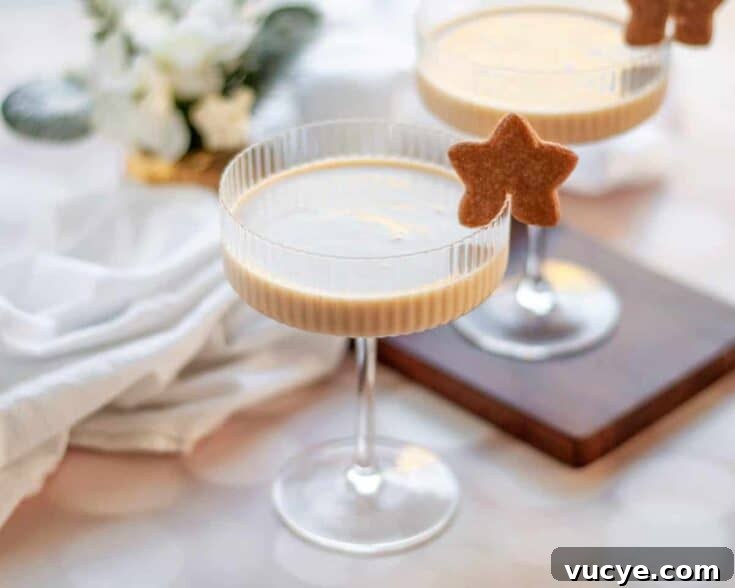 Gingerbread eggnog martini garnished with a gingerbread cookie.