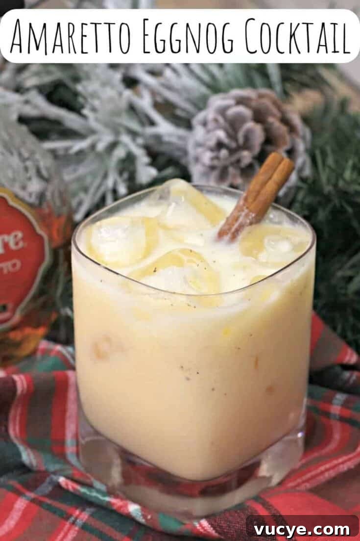 An amaretto eggnog cocktail garnished with a cinnamon stick.