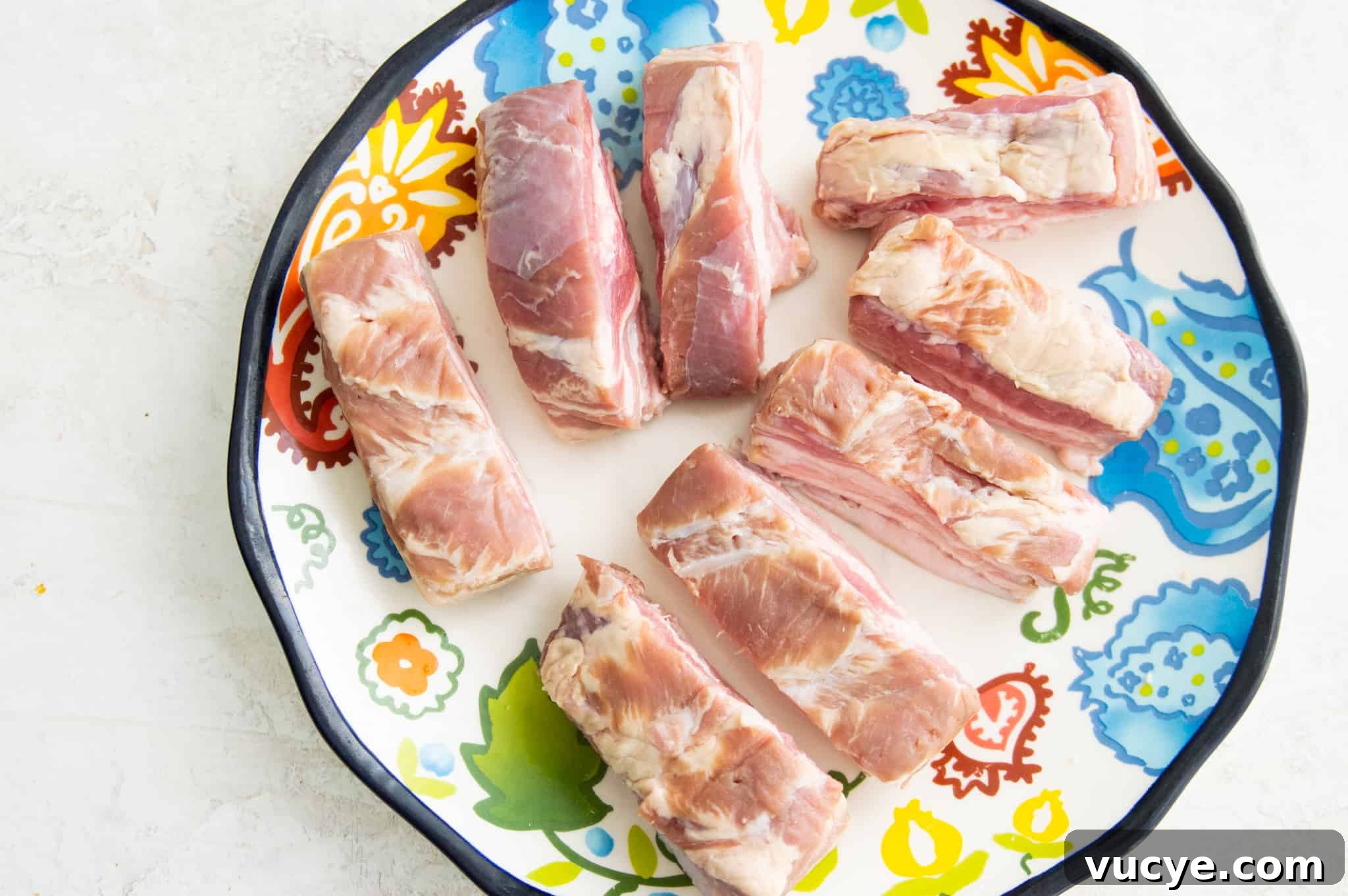 Crispy Air Fryer Pork Belly Bites — Quick Savory Recipe 4 Uncooked pork belly strips on a plate.