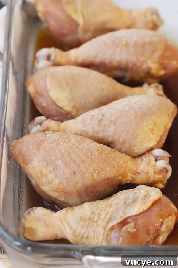 Sticky Honey Soy Chicken Drumsticks: Oven-Baked Glazed Recipe 3 honey and soy chicken drumsticks in a baking dish, ready to bake. Soy sauce chicken drumsticks.