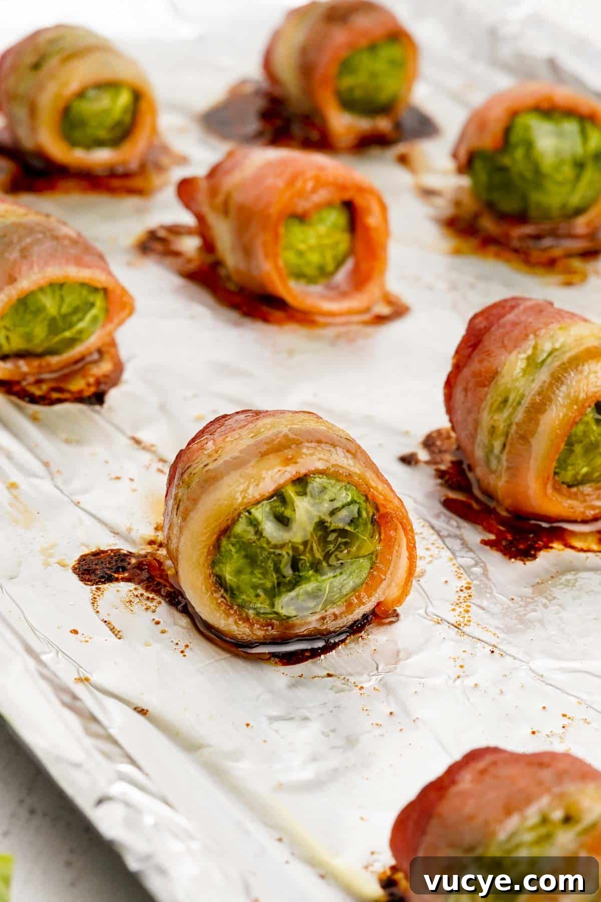 Cooked bacon brussels sprouts on a baking tray.