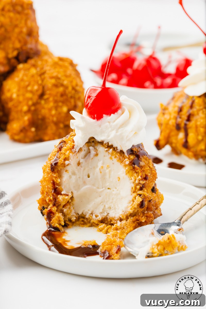 Homemade Fried Ice Cream Recipe: Crispy Shell & Creamy Center 5 a serving of fried ice cream that has had a few bites taken out. Inside the fried ice cream is creamy vanilla, on top is whipped cream and a cherry.