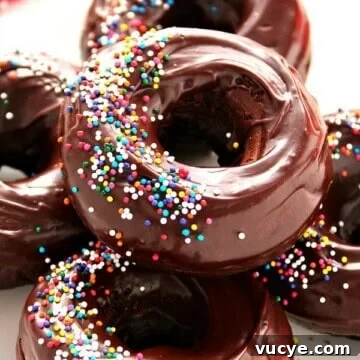 Glazed Chocolate Donuts Recipe: Moist, Shiny Chocolate Glaze 3 Donuts with sprinkles.