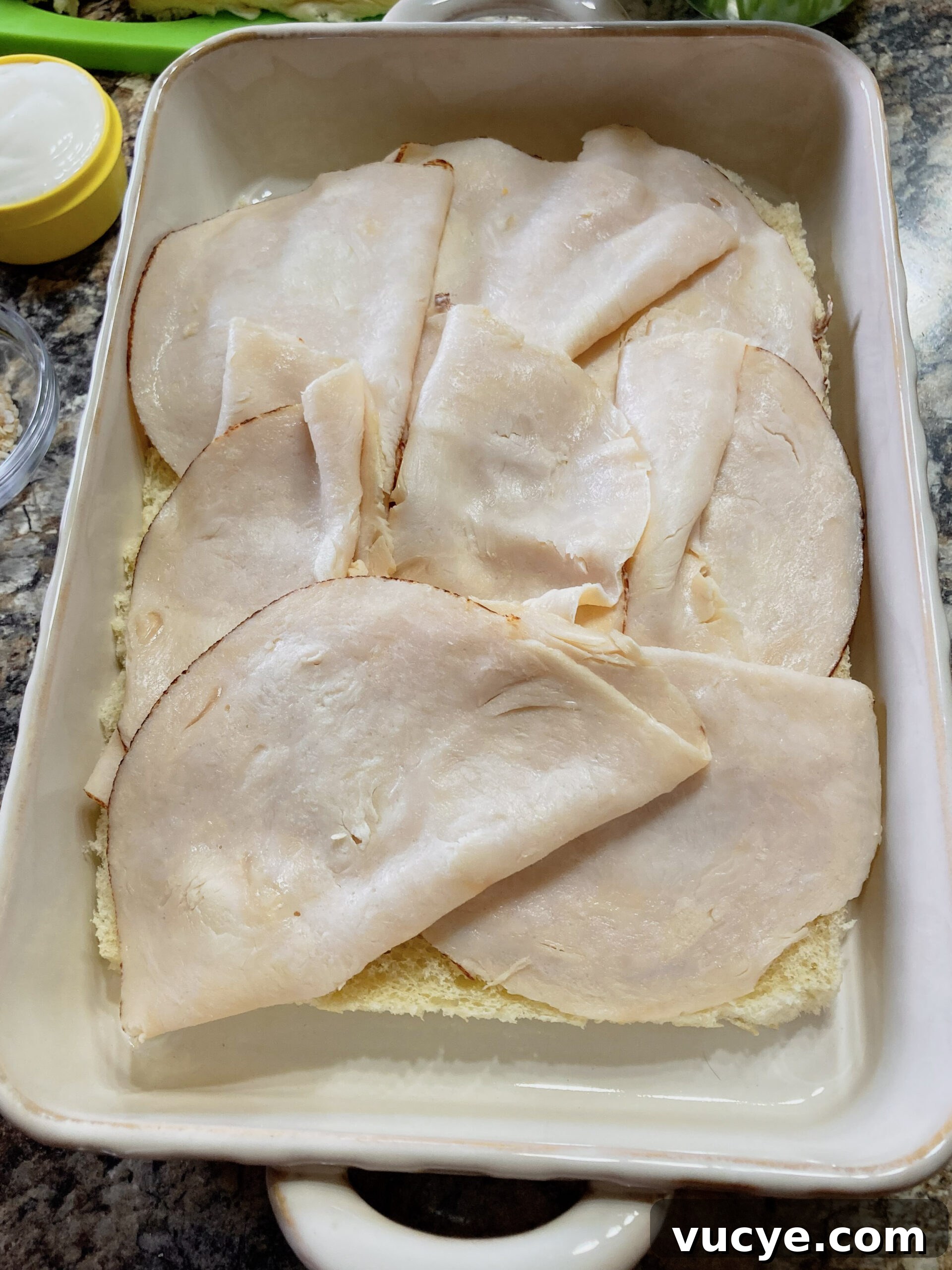 Chicken Bacon Ranch Sliders Recipe: Savory Mini Sandwiches 4 Deli chicken on slider rolls in a casserole dish.