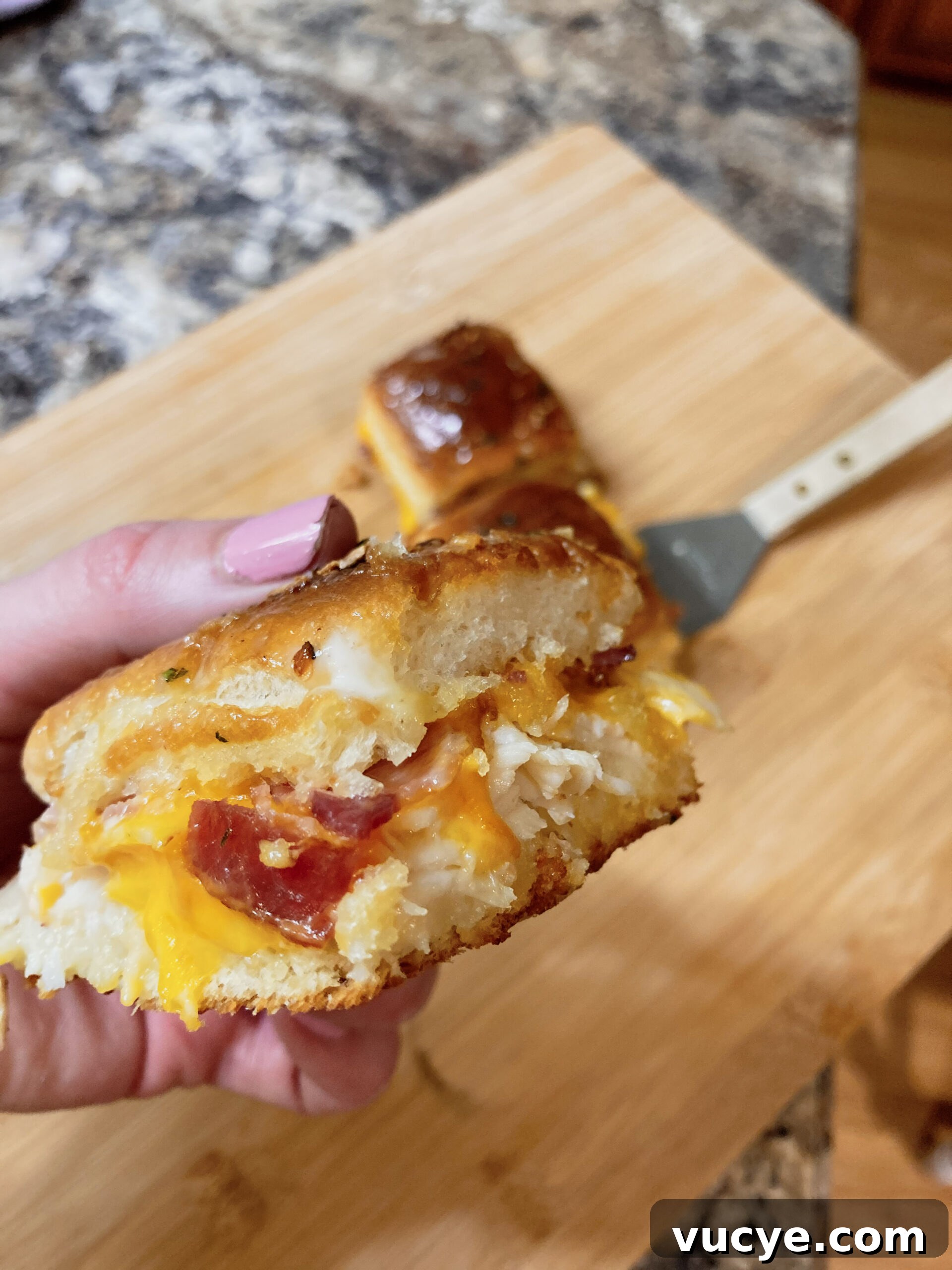 Chicken Bacon Ranch Sliders Recipe: Savory Mini Sandwiches 8 A hand showing the inside of a chicken slider with bacon and ranch.