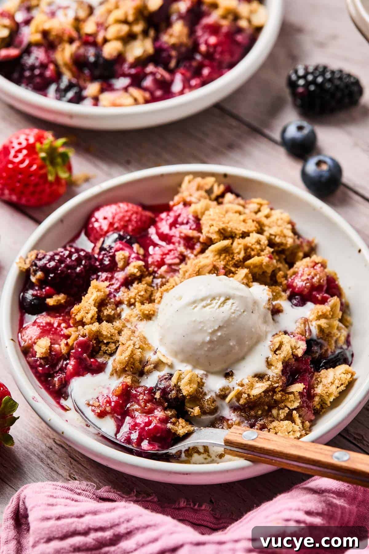 Naturally Sweetened Gluten-Free Berry Crisp Recipe 12 spoon in a bowl with a serving of gluten free berry crisp and a scoop of vanilla ice cream on top