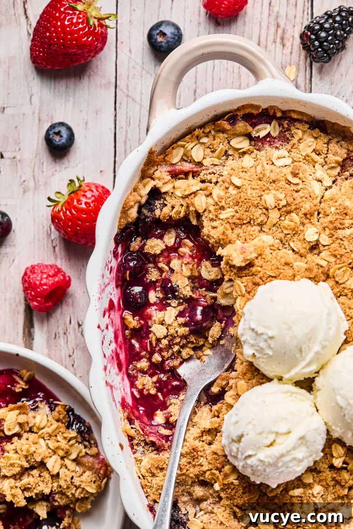 Naturally Sweetened Gluten-Free Berry Crisp Recipe 3 spoon scooped into gluten free berry crisp with two scoops of vanilla ice cream on top