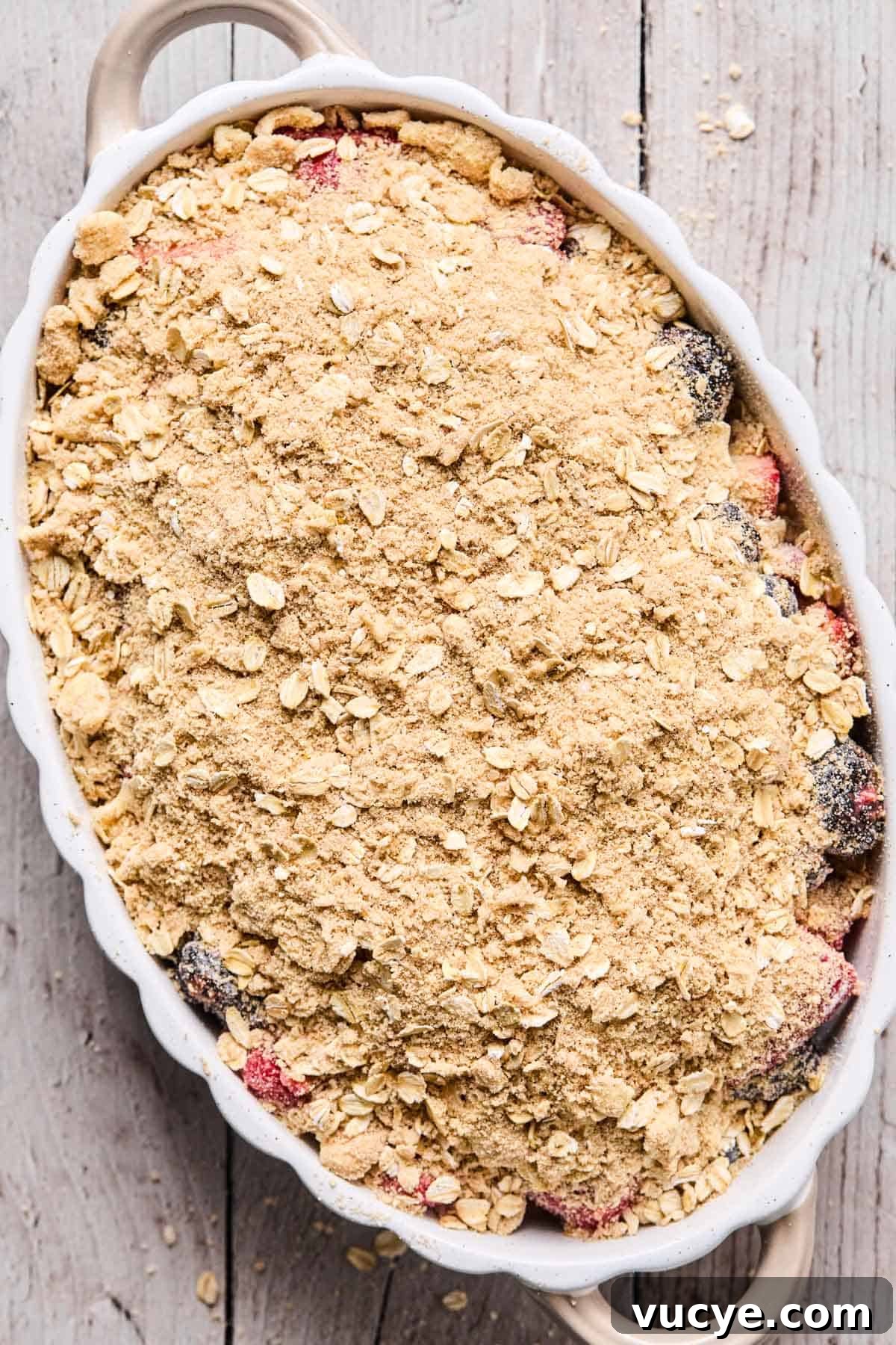 Naturally Sweetened Gluten-Free Berry Crisp Recipe 10 berry mixture covered with oat crisp topping in a baking dish