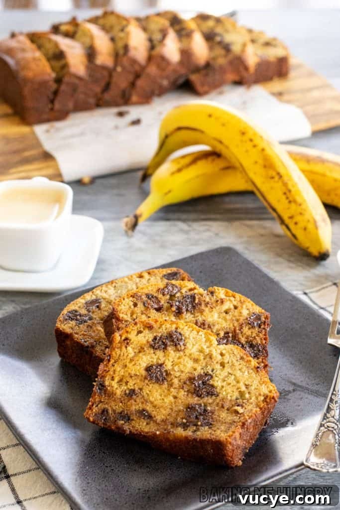 slices of brown butter chocolate chip banana bread on plate with remaining bread behind