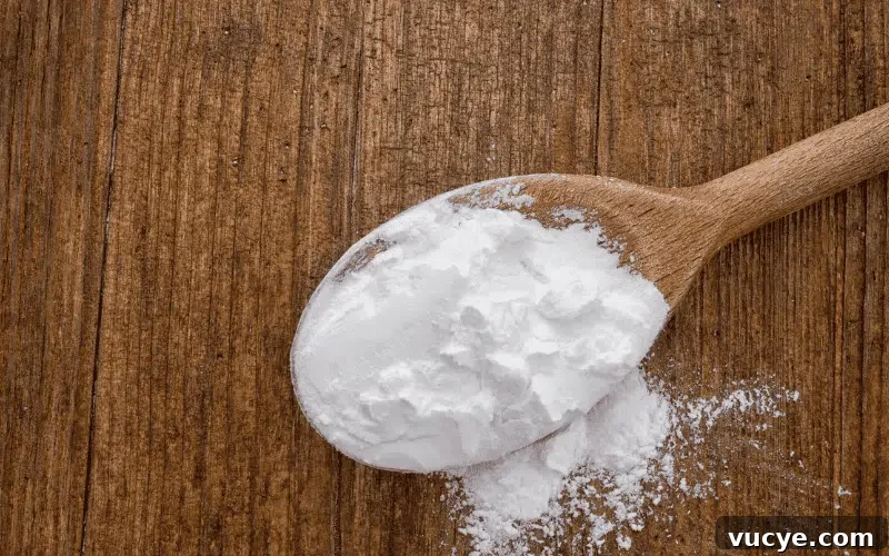 Wooden spoon resting on a wood cutting board with a dusting of white flour.