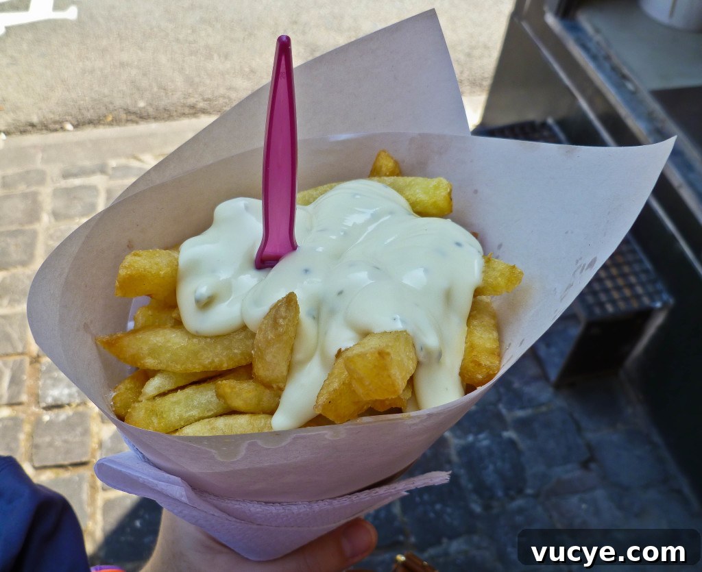 Western European Flavors: Iconic Dishes and Regional Specialties 4 A cone of frites with tartare sauce on top