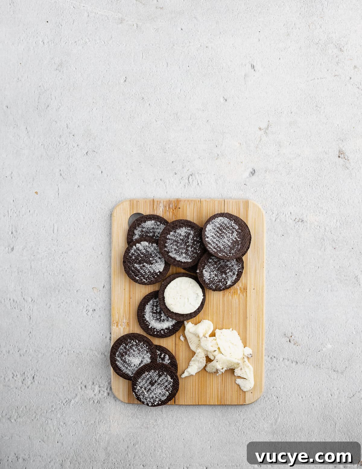 Oreo Chocolate Chip Cookies Recipe — Crispy Edges, Chewy Center 5 Oreo cookies on a cutting board with the filling removed from them.