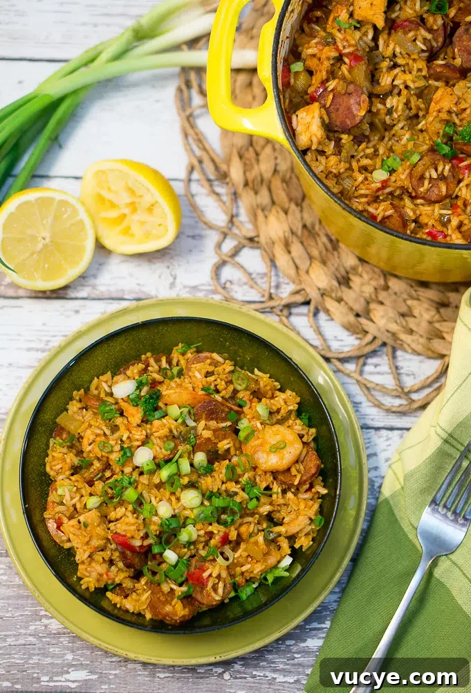 jambalaya served in a green bowl with sliced green onions