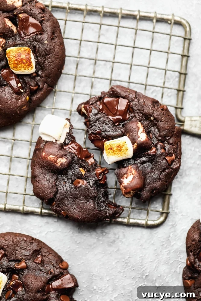 Chewy Chocolate Marshmallow Cookies with Gooey Centers 2 chocolate marshmallow cookie split in half on a wire cooling rack