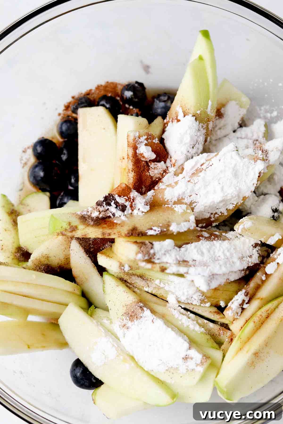 Apple and Blueberry Crumble Recipe: Light, Fruity Dessert Guide 3 Blueberries, apples, arrowroot, cinnamon, cardamom, vanilla, and maple syrup in a bowl.