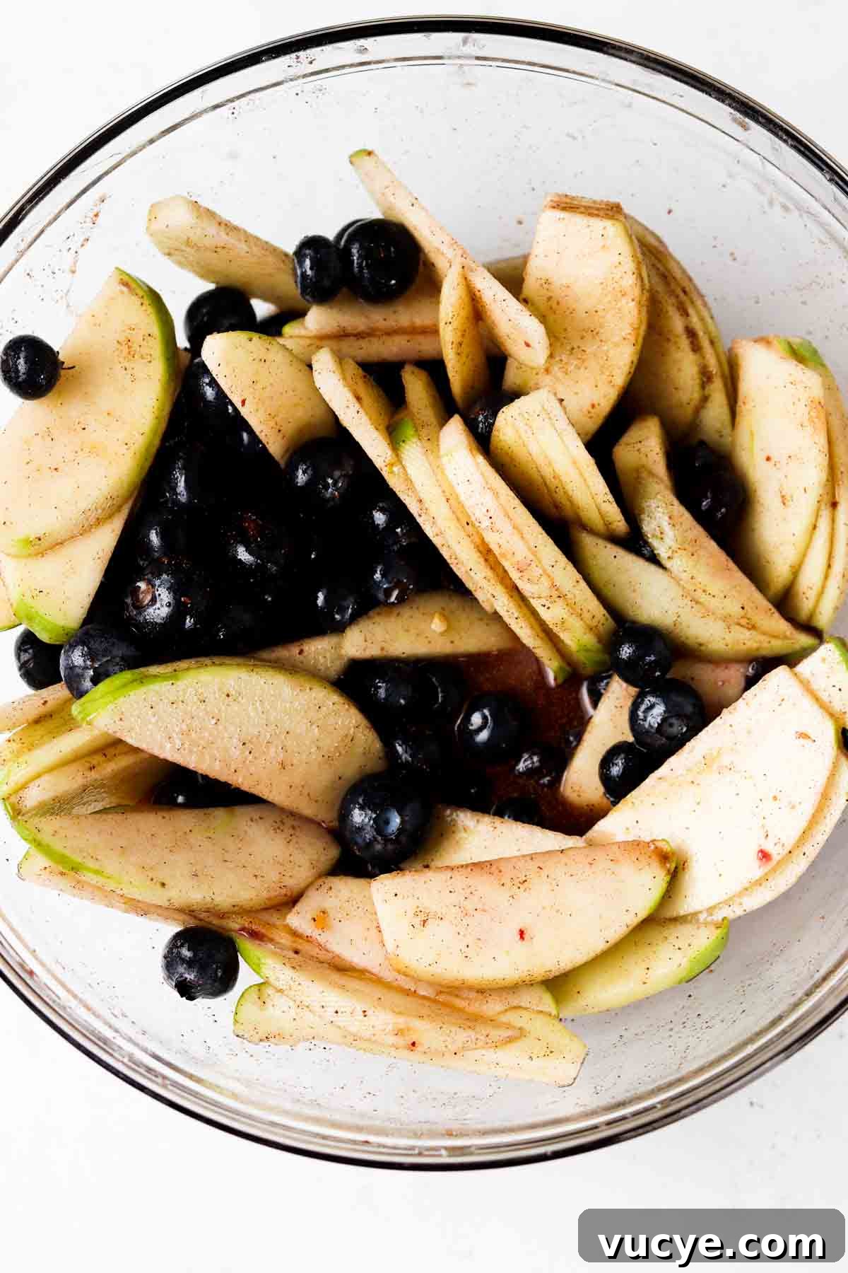 Apple and Blueberry Crumble Recipe: Light, Fruity Dessert Guide 4 Apples and blueberries tossed with spices and arrowroot in a bowl.
