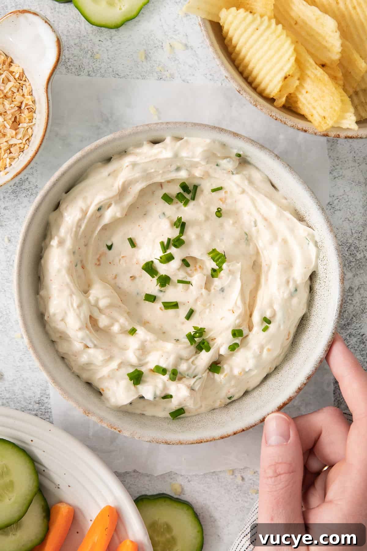 Chip dip in a bowl topped with fresh chives.