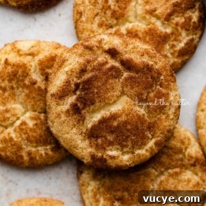 Classic Chewy Snickerdoodle Cookie Recipe for Perfect Cinnamon Cookies 13 Snickerdoodle cookies on a parchment paper lined baking sheet.