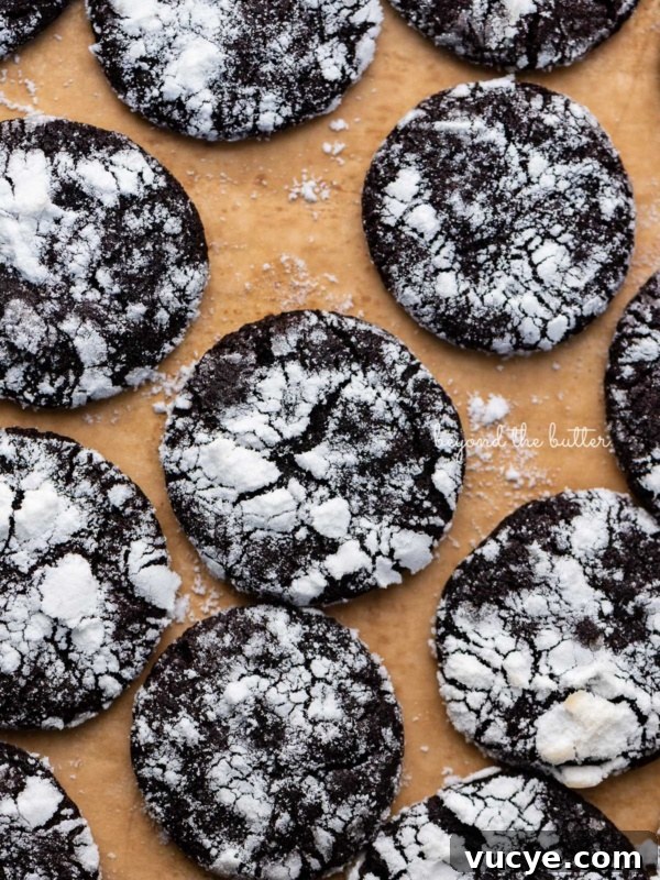 Classic Chewy Snickerdoodle Cookie Recipe for Perfect Cinnamon Cookies 9 Just baked dark chocolate crinkle cookies on a brown parchment paper lined baking sheet.