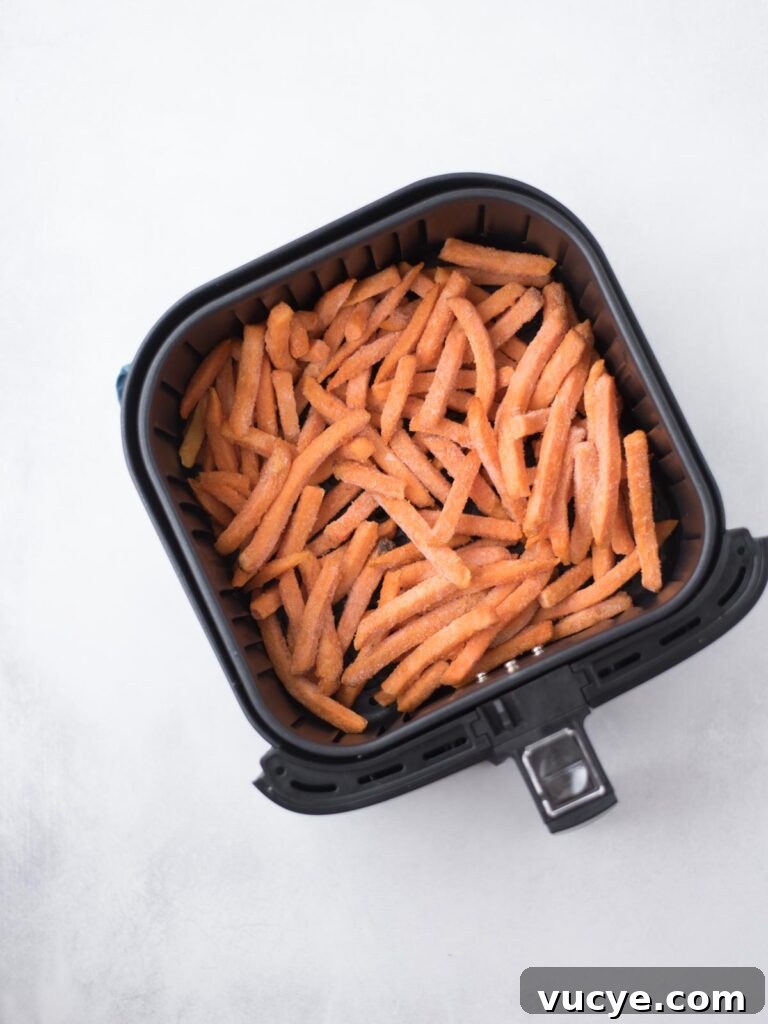 Crispy Air Fryer Sweet Potato Fries from Frozen 5 Frozen sweet potato french fries added to the air fryer bucket.