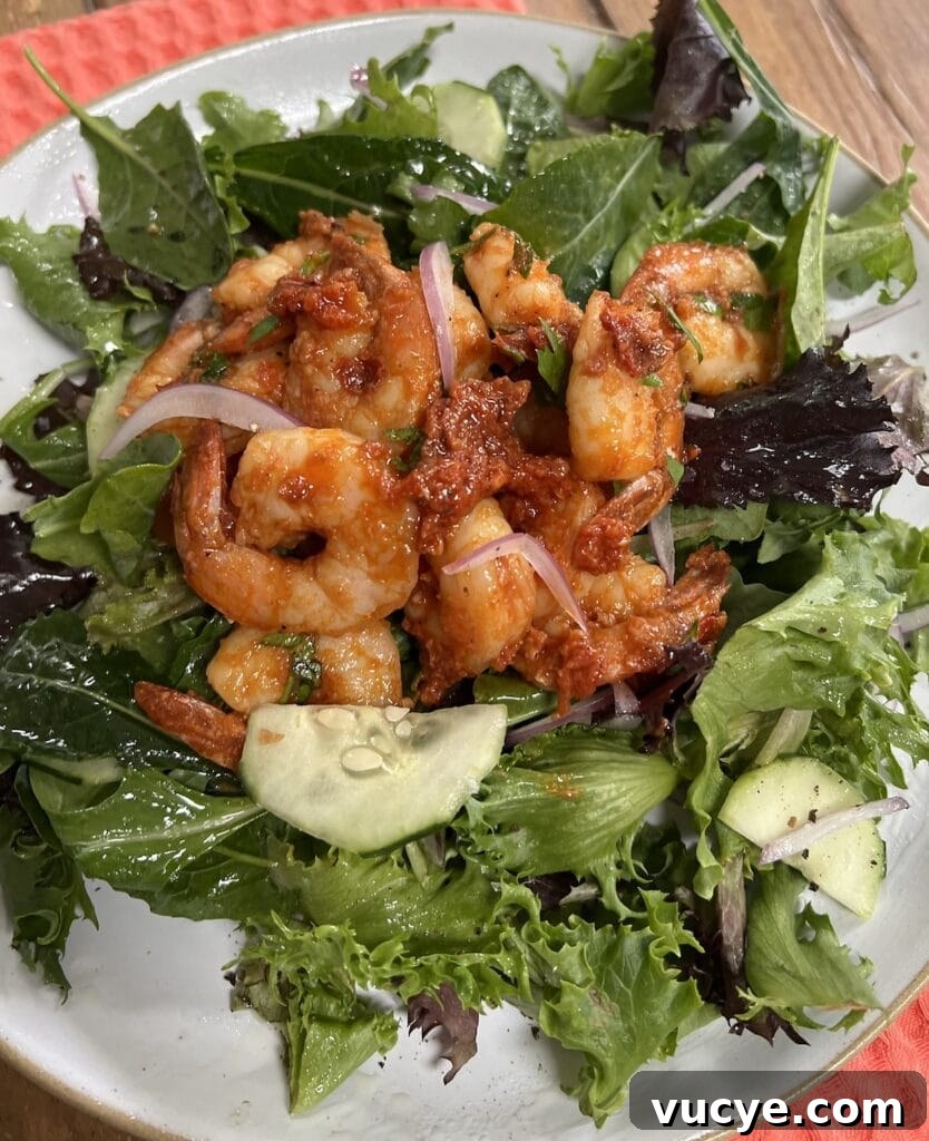 Spicy tomato shrimp over a mixed green salad.