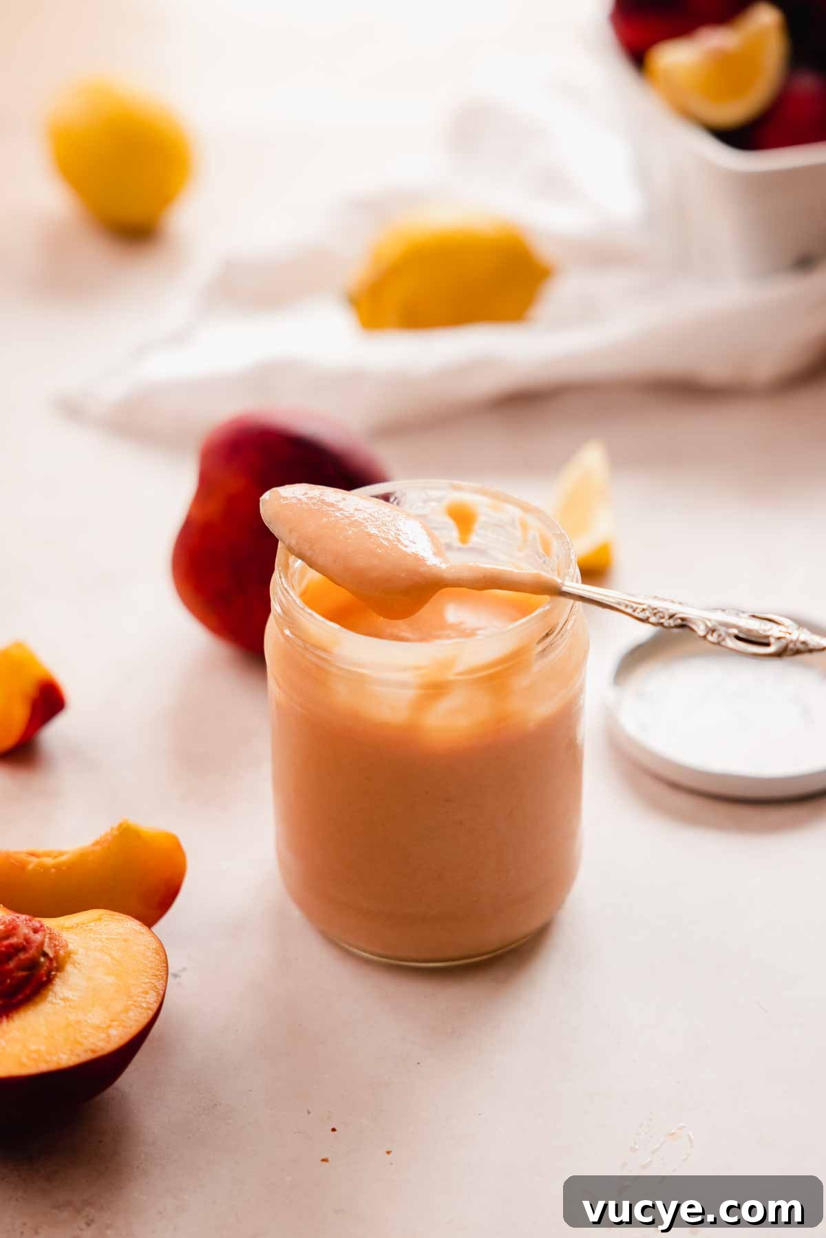 Silky Homemade Peach Curd Recipe for Tarts & Toast 16 a spoon full of peach curd resting on a jar