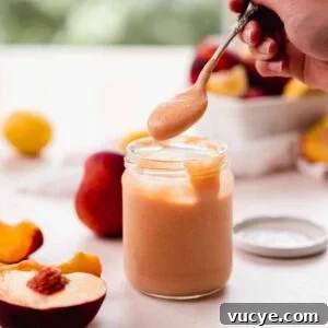 Silky Homemade Peach Curd Recipe for Tarts & Toast 17 scooping the curd with a spoon from a glass jar