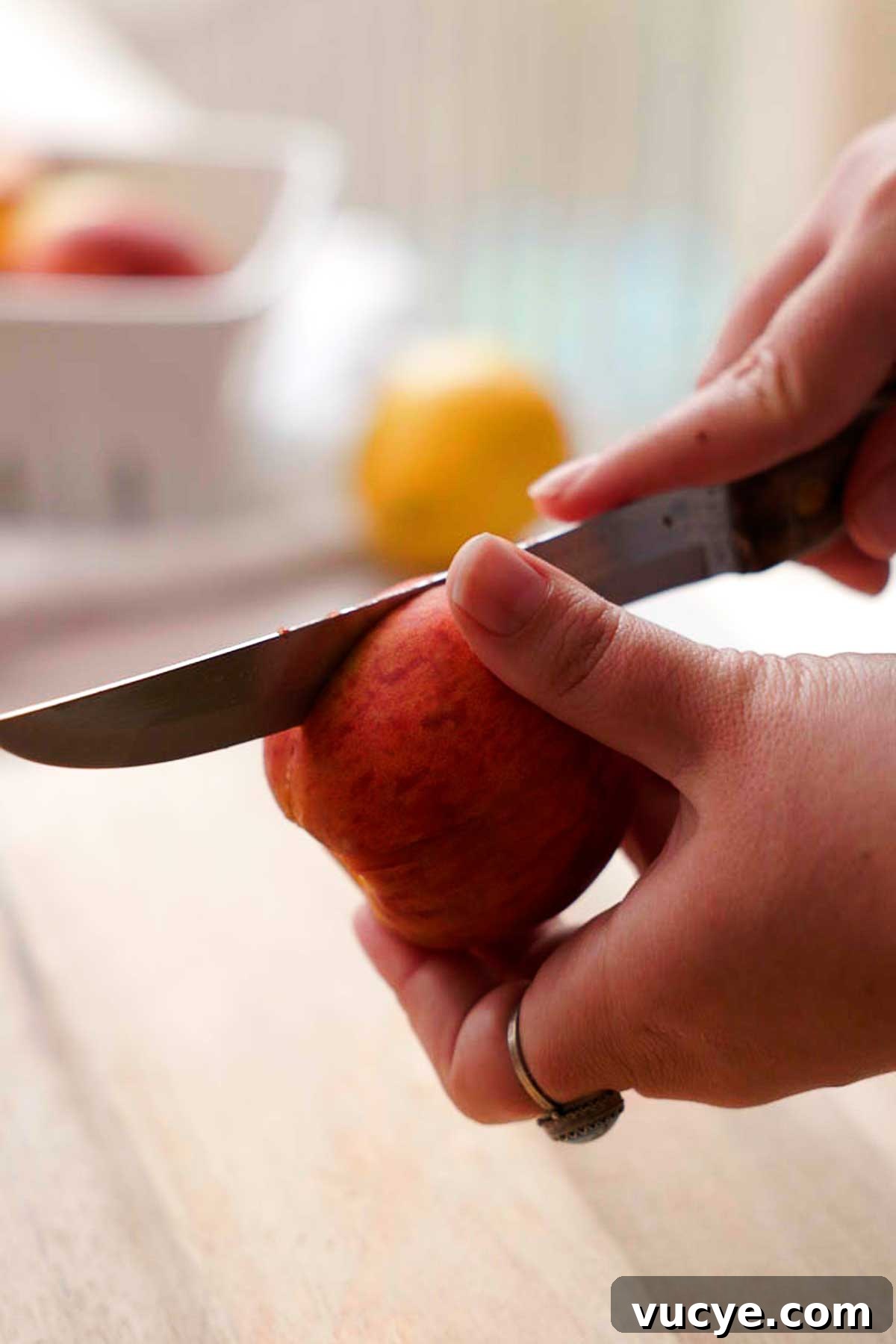 Silky Homemade Peach Curd Recipe for Tarts & Toast 5 cutting a peach in half with a knife