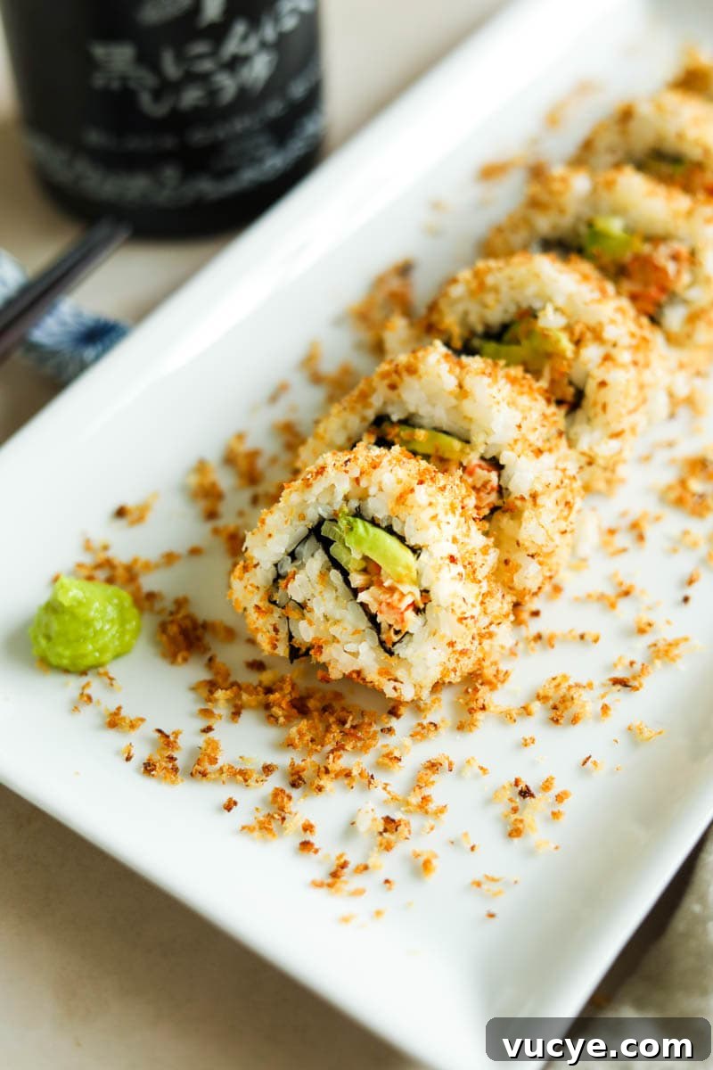 Spicy Crunchy California sushi roll tossed in a crispy panko crust on a white plate with wasabi.