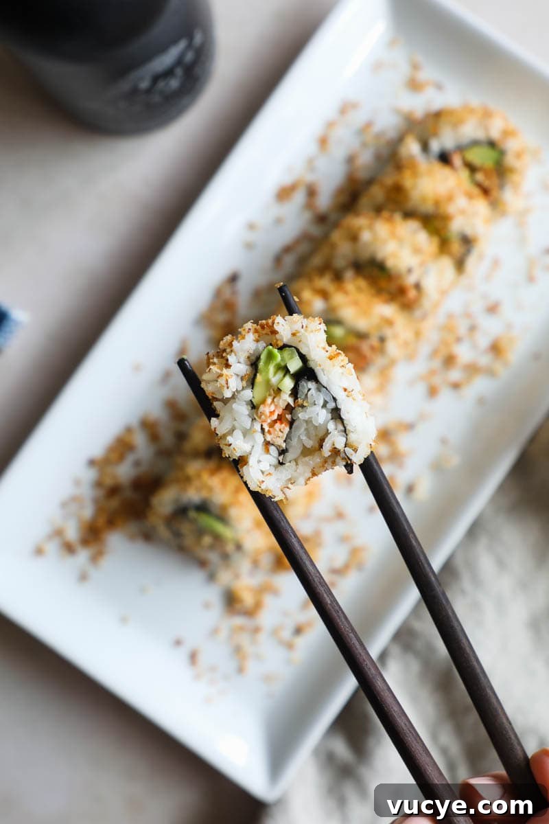 Spicy California Crunch Sushi Roll held in chopsticks.