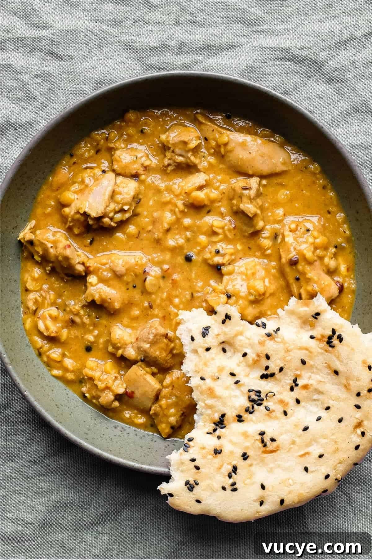 Chicken & Lentil Curry | cookeatworld.com A bowl of lentil curry with a piece of naan bread