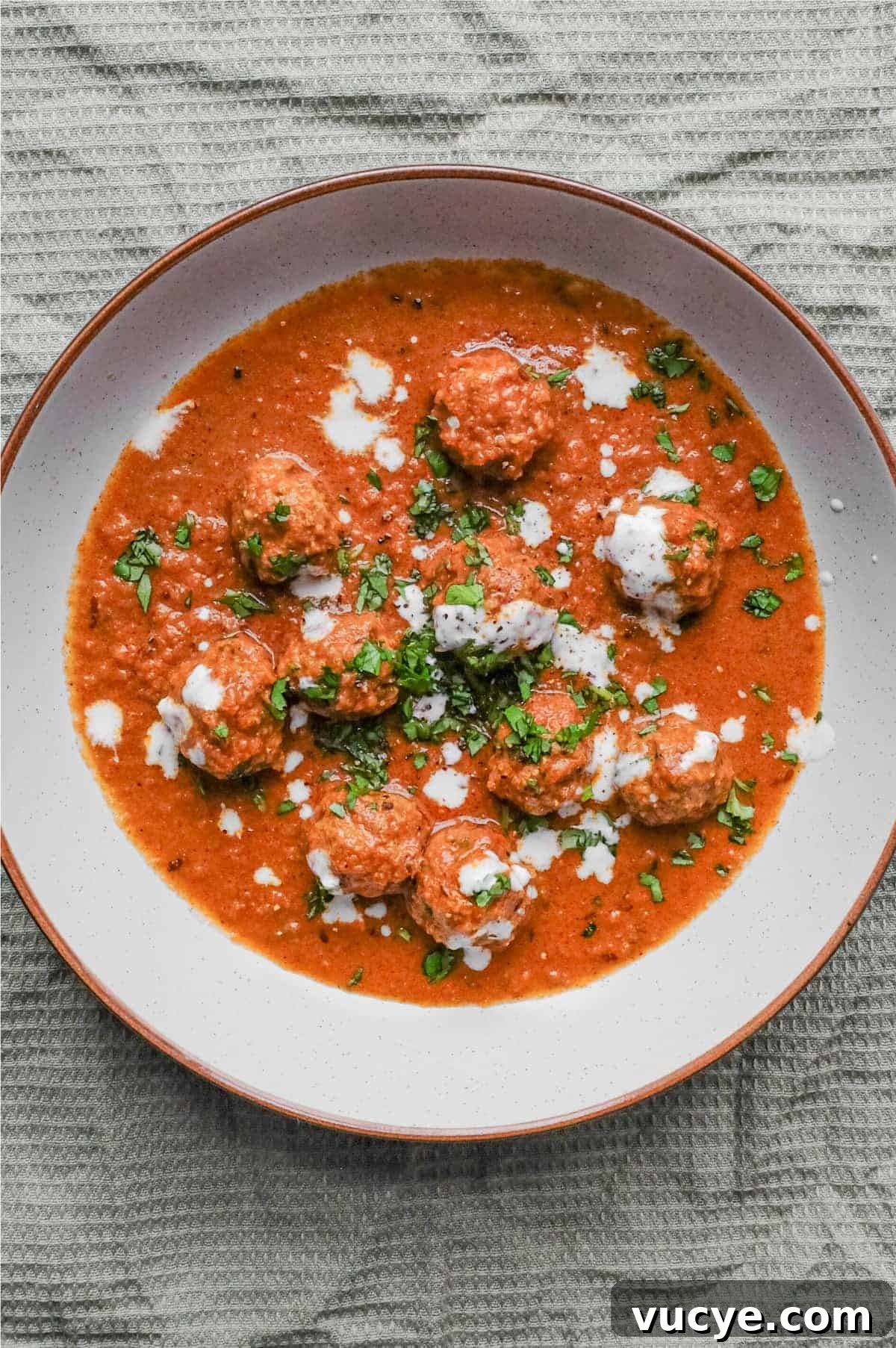Kofta Curry | cookeatworld.com A bowl of Kofta (meatball) curry drizzled with yoghurt and garnished with chopped cilantro