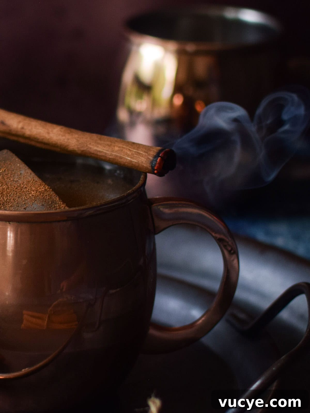 Cinnamon stick on a mug lit on fire.