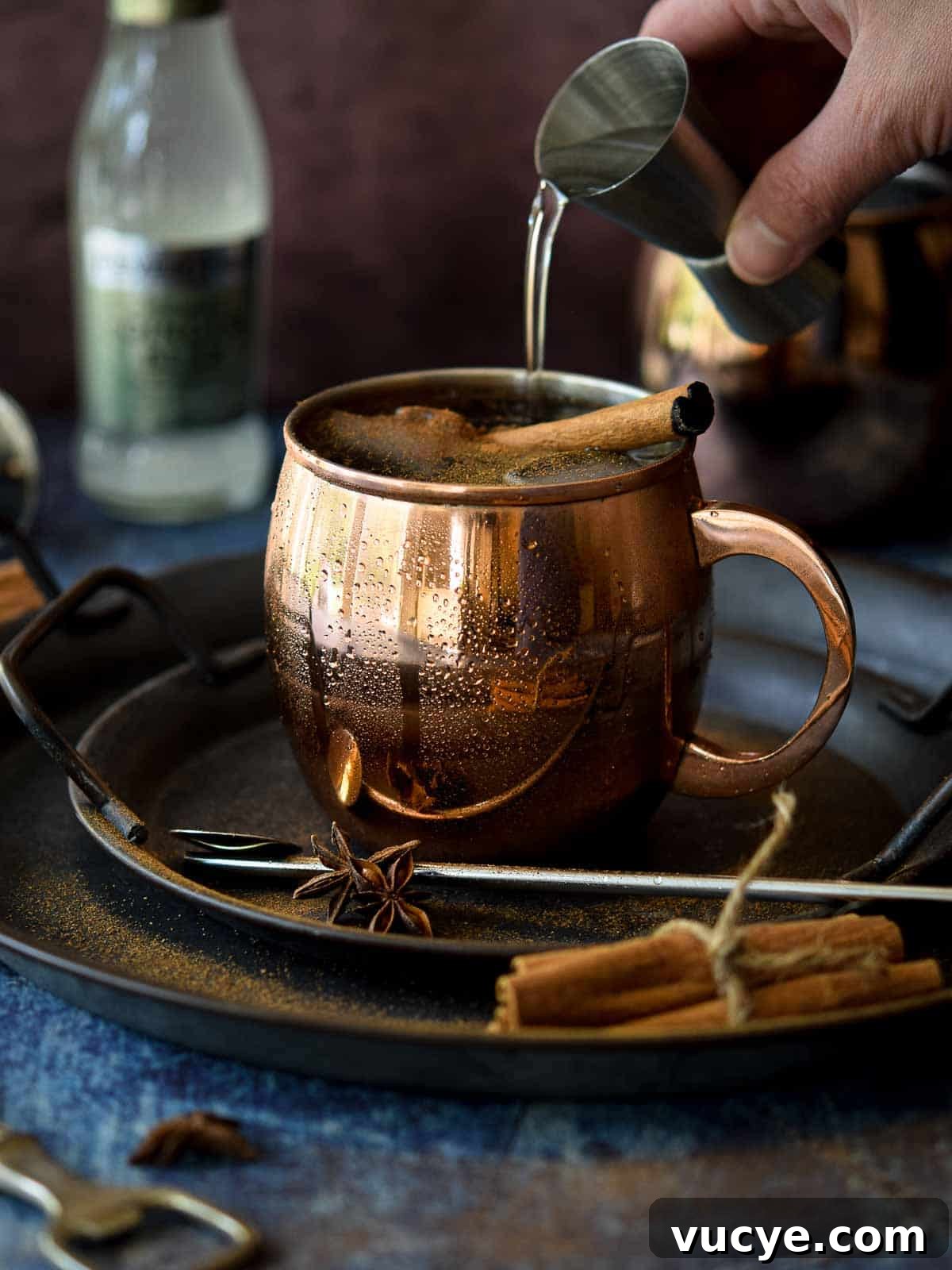 Chai Moscow mule in a copper mug with vodka being poured in.