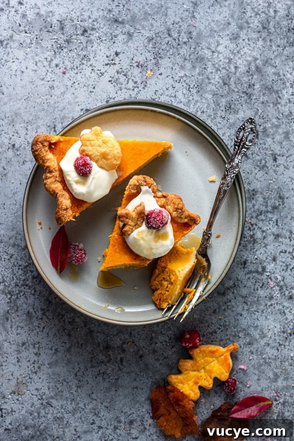 Pumpkin Cheesecake Pie sliced on a grey plate with a fork. 