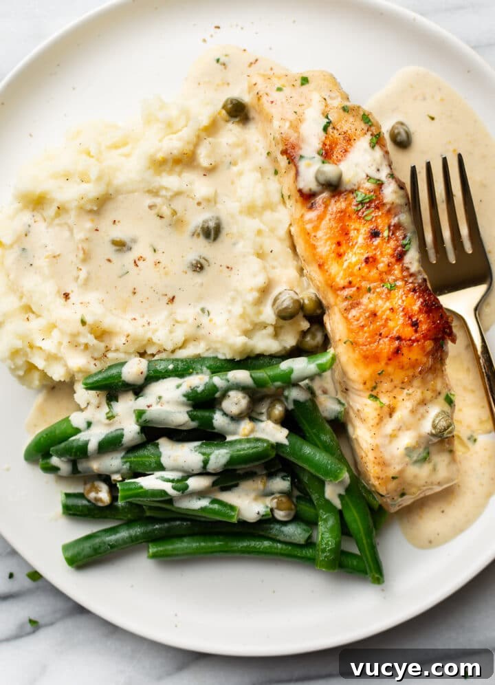 Creamy Lemon Salmon Piccata Recipe for Weeknight Dinners 6 a plate with salmon piccata, mashed potatoes, and green beans