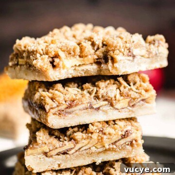 Stack of apple crisp bars with a bite removed from the top square.