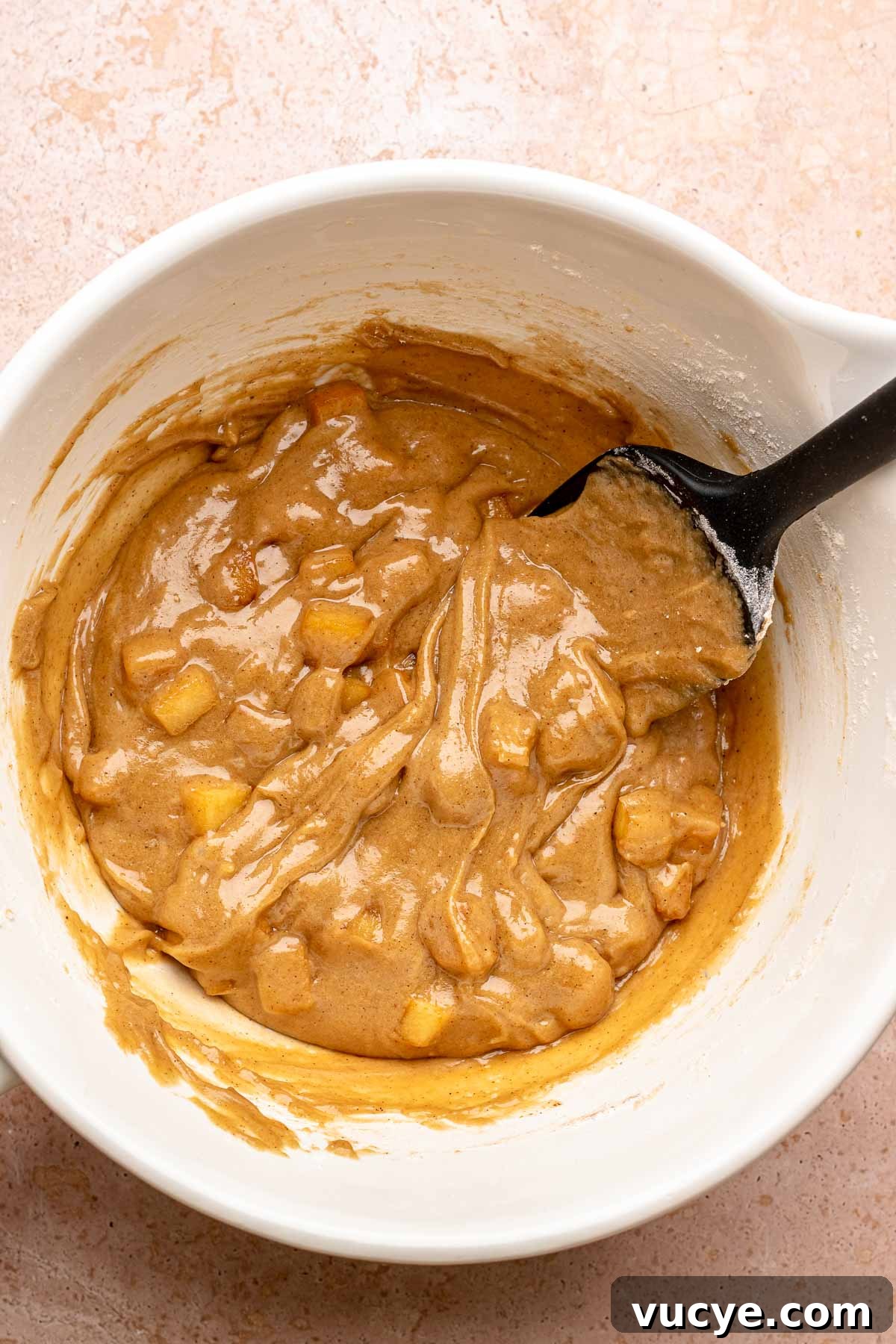 Apple Cinnamon Blondie Recipe — Chewy Spiced Apple Bars 6 A spatula mixes blondie batter with apples.
