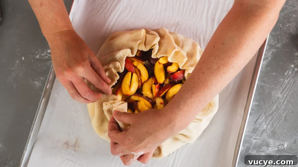 Rustic Peach Pie Recipe with a Flaky Homemade Crust 3 Pinching the dough corners of a rustic peach pie recipe