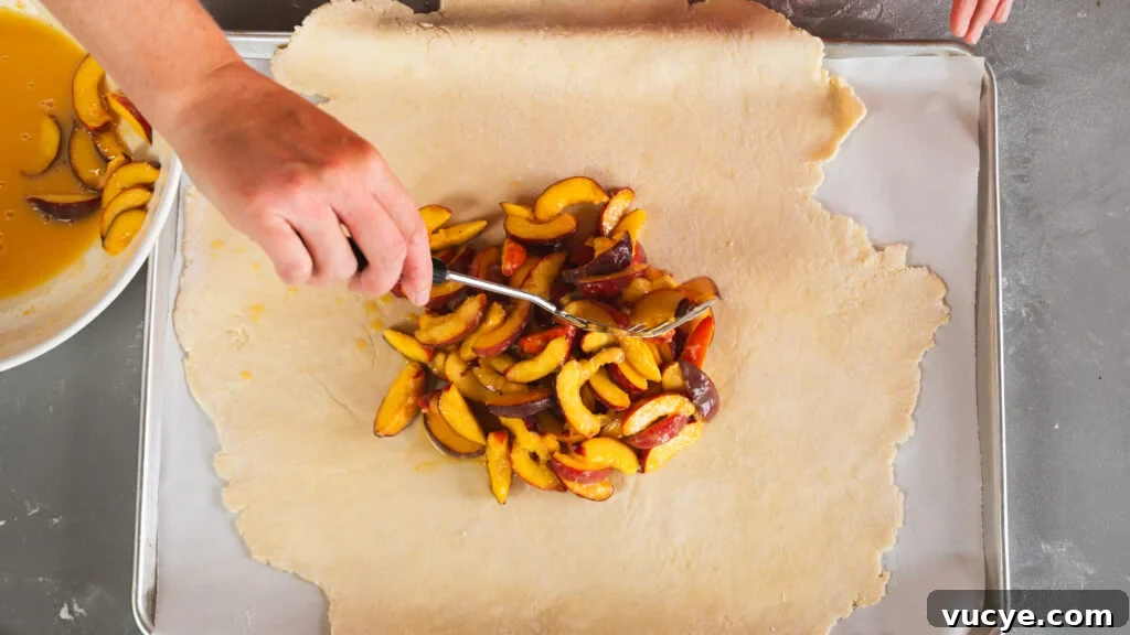 Rustic Peach Pie Recipe with a Flaky Homemade Crust 5 Adding peach filling to the center of a rustic peach tart.