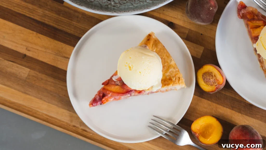 Rustic Peach Pie Recipe with a Flaky Homemade Crust 7 A slice of peach pie with a scoop of vanilla ice cream on top.
